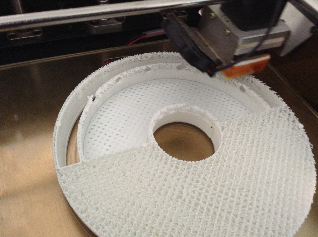 A 3D printer nozzle over part of my designed object on the printer stage